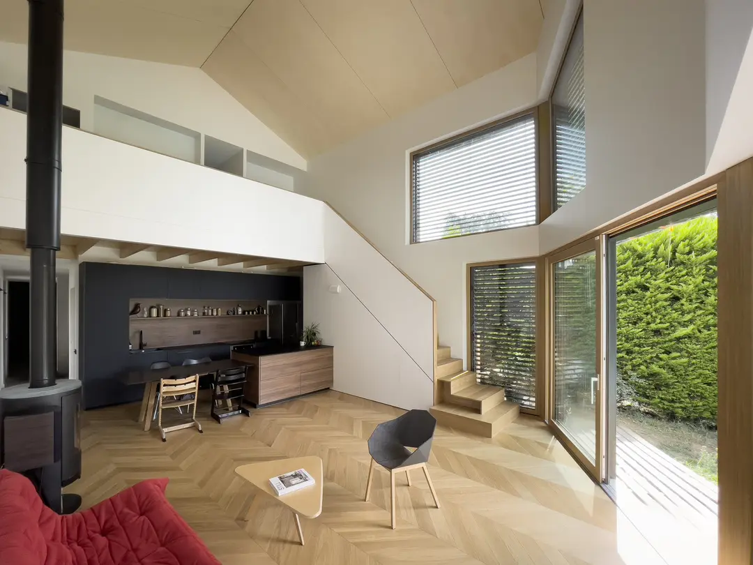Maison passive en ossature bois à Francheville, séjour en double hauteur avec plafond bois et grandes baies triple vitrage