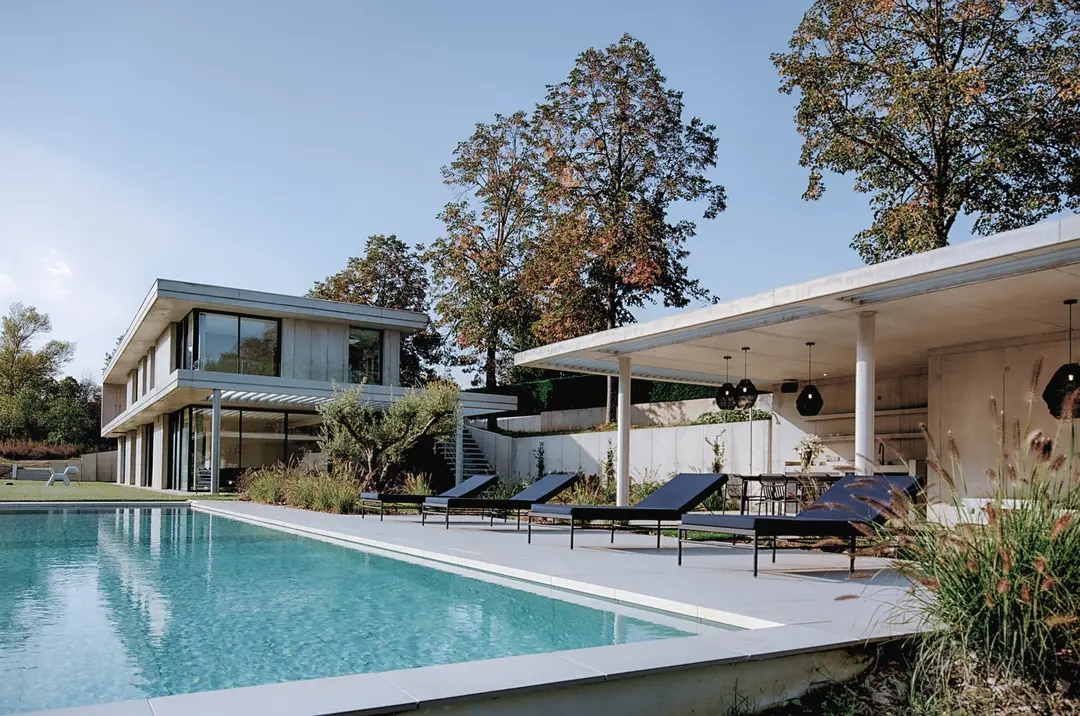 Piscine et pool house de la maison en béton banché de Tassin-la-Demi-Lune, maison contemporaine sur deux niveaux à l'arrière-plan