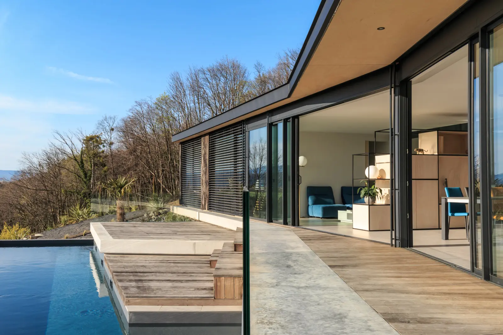 Intérieur de la maison dans la pente, lumière naturelle des grandes baies vitrées