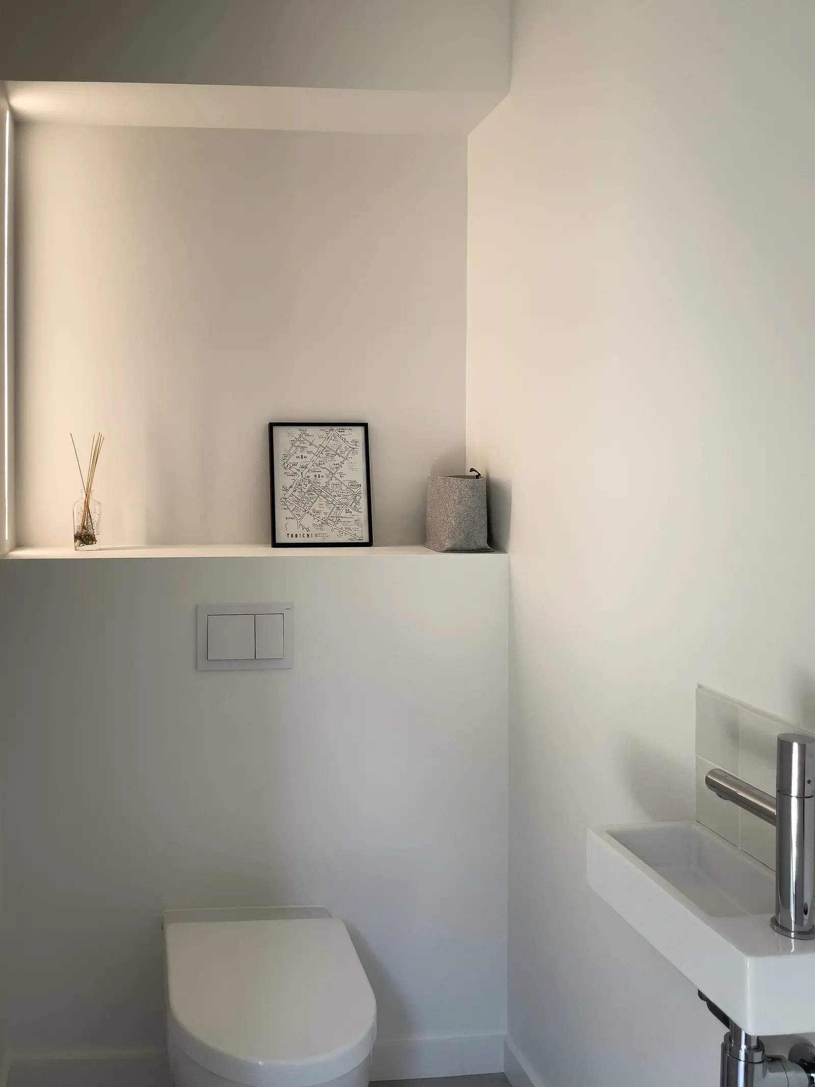 WC épuré de la maison passive de Francheville, cuvette suspendue, niche et bandeau lumineux
